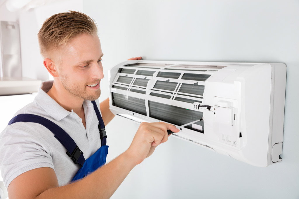 HVAC technician performing ductless air conditioning maintenance in Saratoga Springs