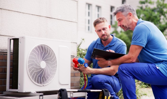 HVAC technicians installing an outdoor air conditioning unit in Saratoga Springs