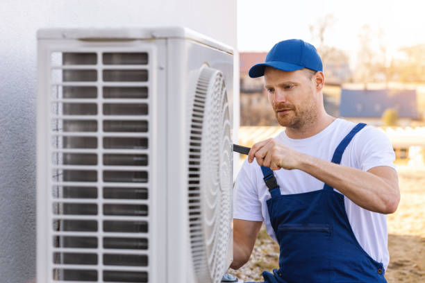 HVAC technician servicing an outdoor air conditioning unit in Saratoga Springs