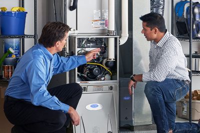 65df8c11f3e4c468cbd351a5_furnace repair vs replacement – Copy HVAC technician explaining furnace repair and maintenance to a homeowner in Saratoga Springs, UT