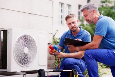 ac-installation-in-claremont-ca HVAC technicians reviewing an outdoor air conditioning unit in Saratoga Springs, UT