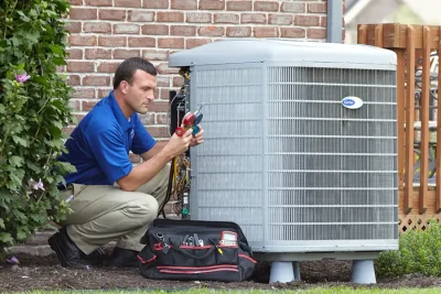 design-air-heating-and-air-conditioning-decatur-il-05 – Copy HVAC technician inspecting an outdoor air conditioning unit in Saratoga Springs, UT