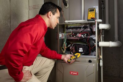 furnace repair Heating and air conditioning technician servicing an indoor furnace in Saratoga Springs, UT